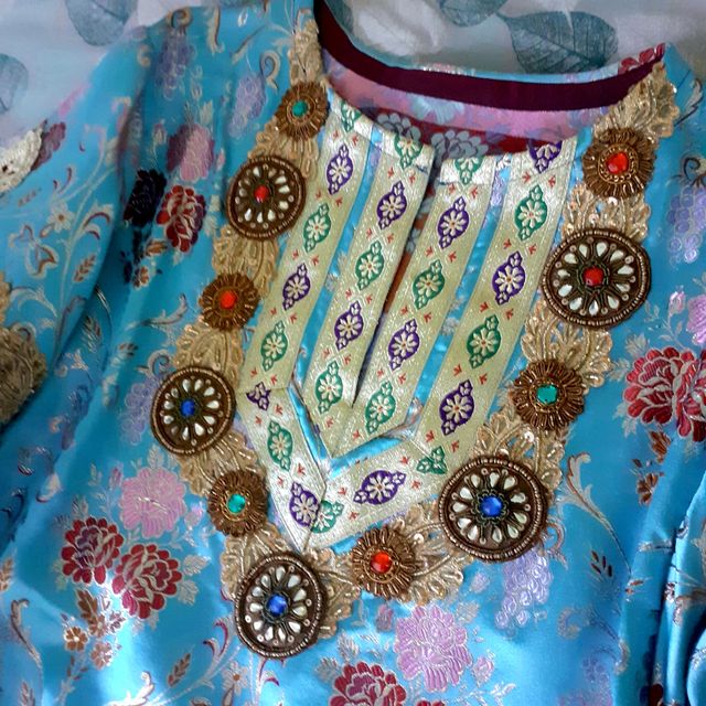 Túnica en brocado azul y pedrería.