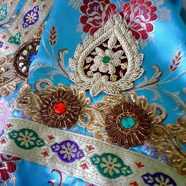 Túnica en brocado azul y pedrería.
