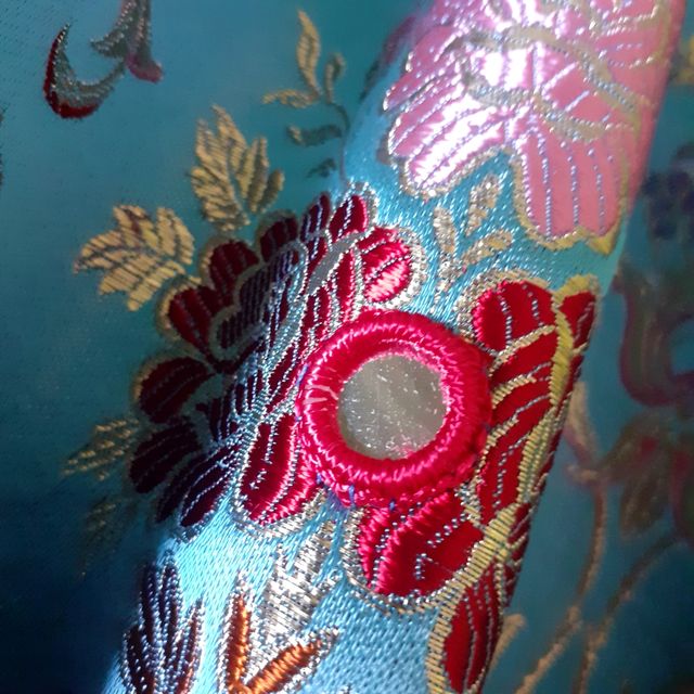 Túnica en brocado azul y pedrería.