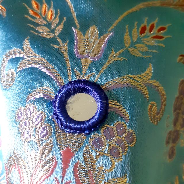 Túnica en brocado azul y pedrería.