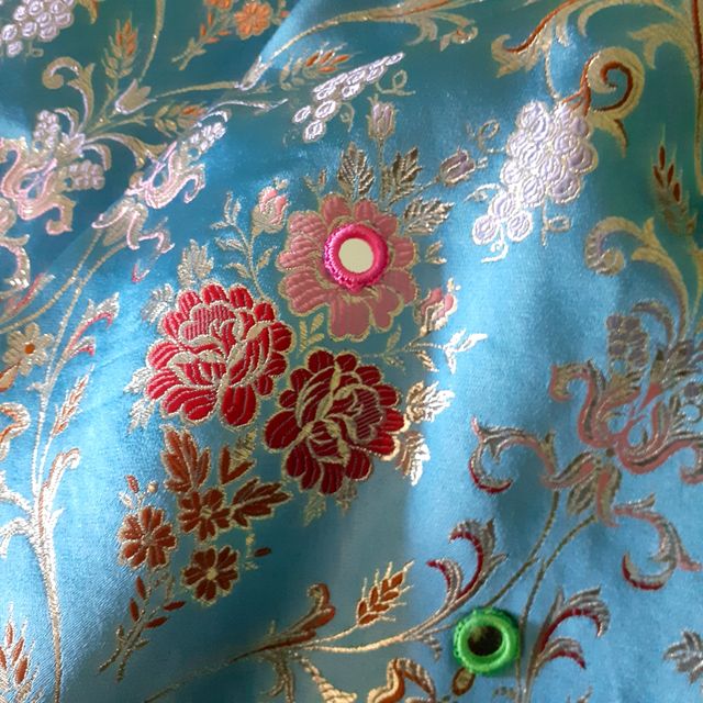 Túnica en brocado azul y pedrería.