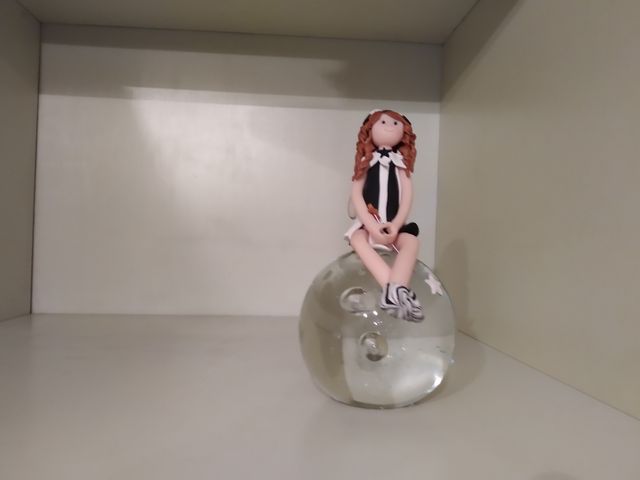 Hada sentada sobre el mundo de pasta fimo