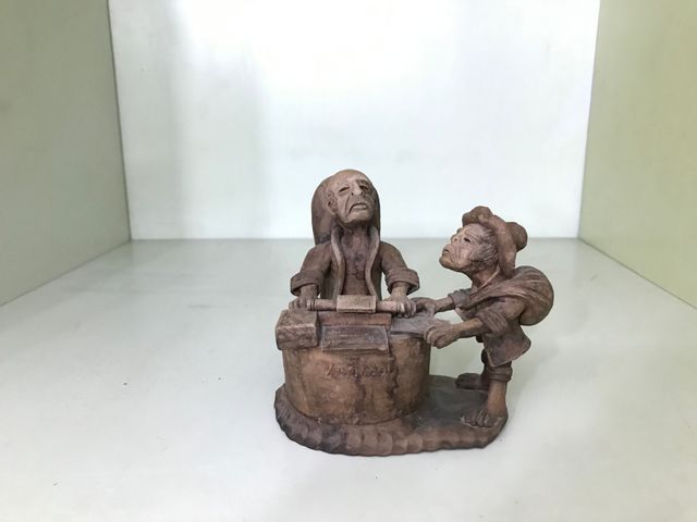 Figuras de barro abogado y mujer comiendo sandia