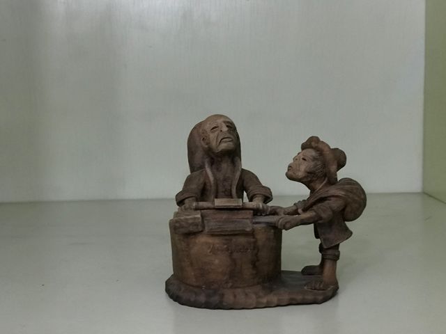 Figuras de barro abogado y mujer comiendo sandia