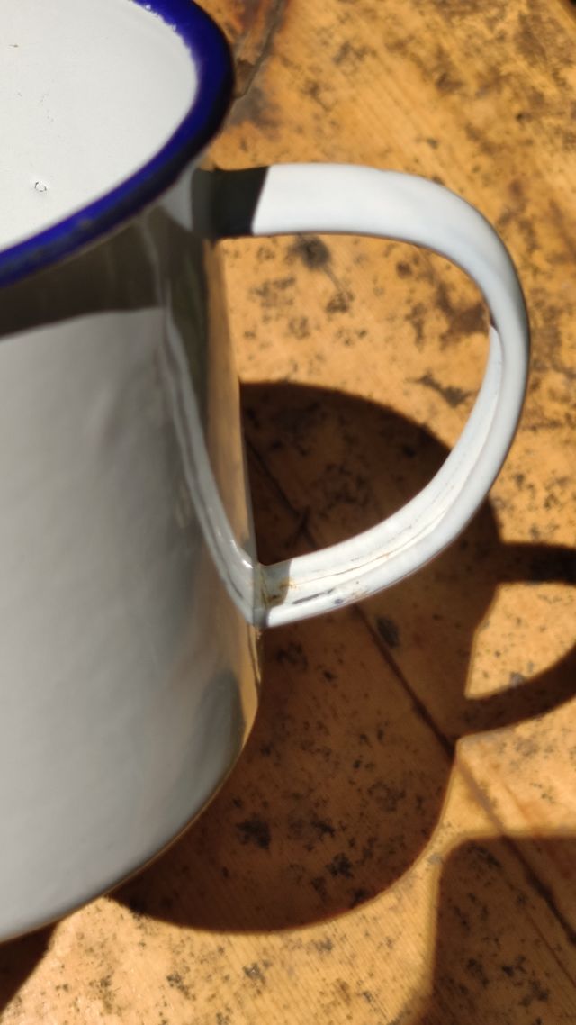 Antigua taza de metal esmaltada