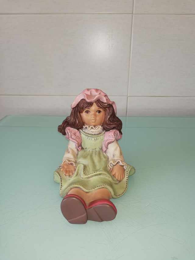 CERAMICA NIÑA SENTADA.SUJETA LIBROS