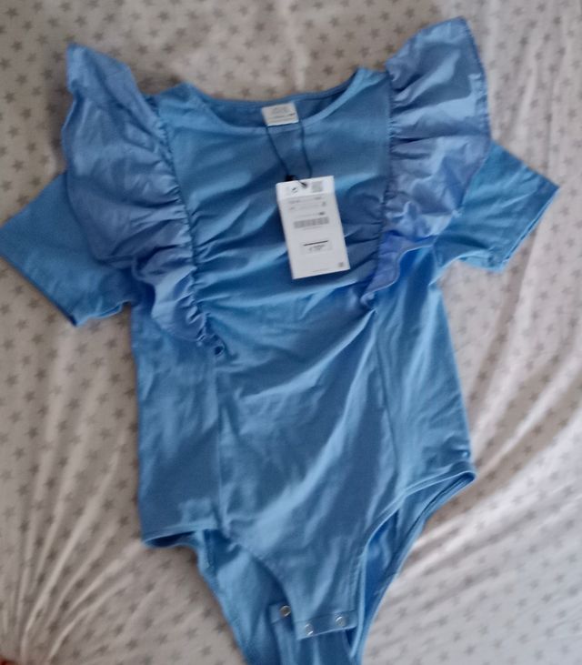 Body con volantes en la manga color azul.