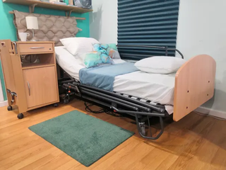 Cama articulada con carro elevador y barandillas .