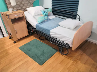 Cama articulada con carro elevador y barandillas .