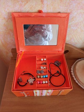 Joyero de tela naranja con tapa.