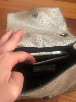 Bolso de piel plateada con cadena.