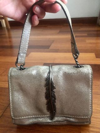 Bolso de piel plateada con cadena.