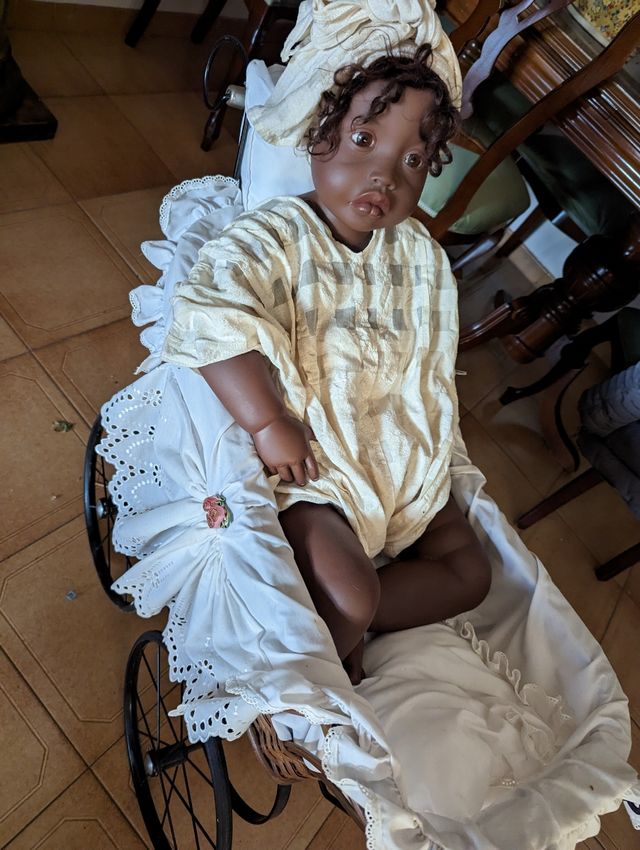 Muñeca en coche de niño. No es cerámica.
