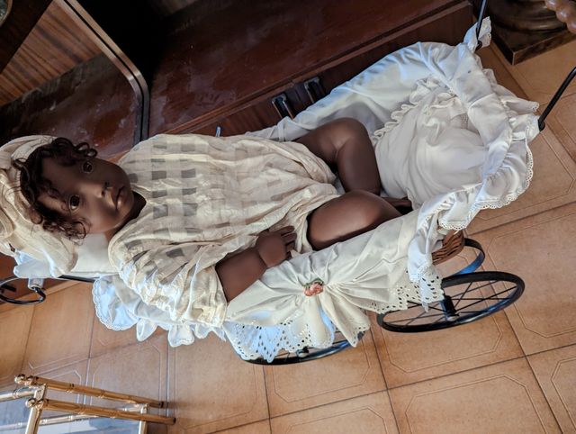 Muñeca en coche de niño. No es cerámica.