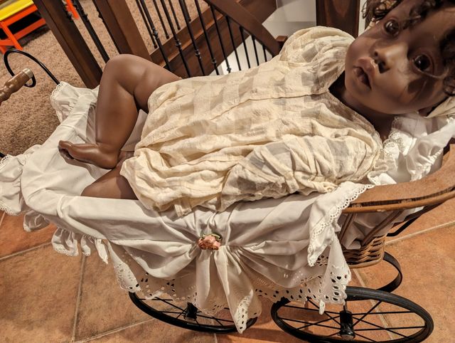 Muñeca en coche de niño. No es cerámica.