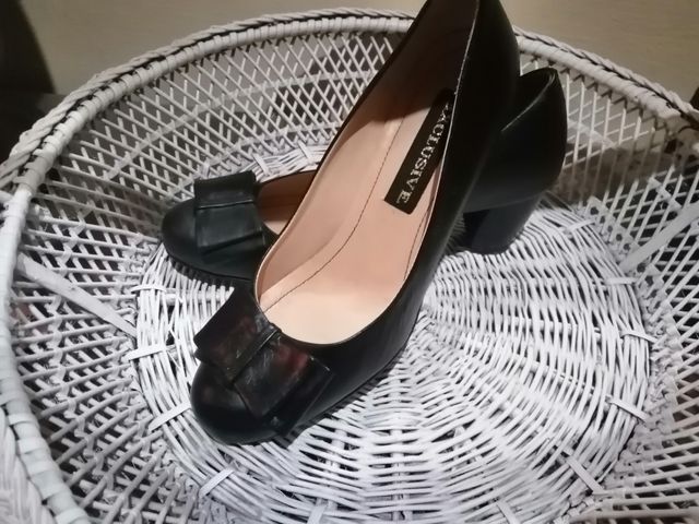 Zapatos negros de piel con tacon bajo.