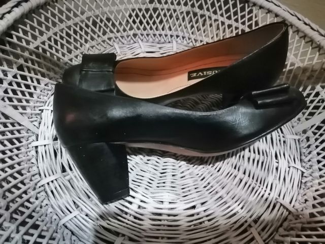 Zapatos negros de piel con tacon bajo.