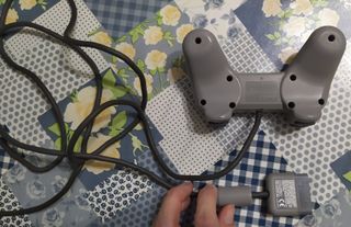 Playstation 1 con un mando original y cables