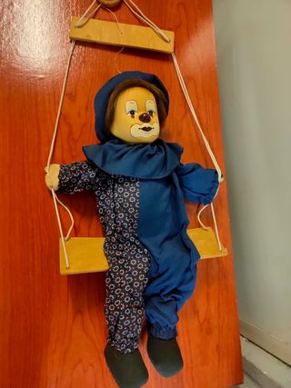 muñeco arlequín sobre columpio