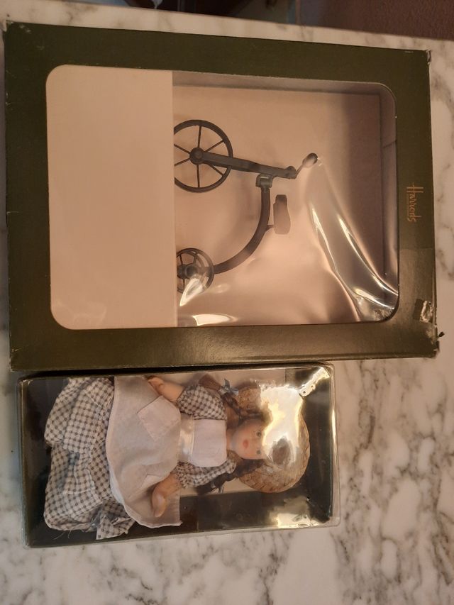 Muñeca porcelana y triciclo.