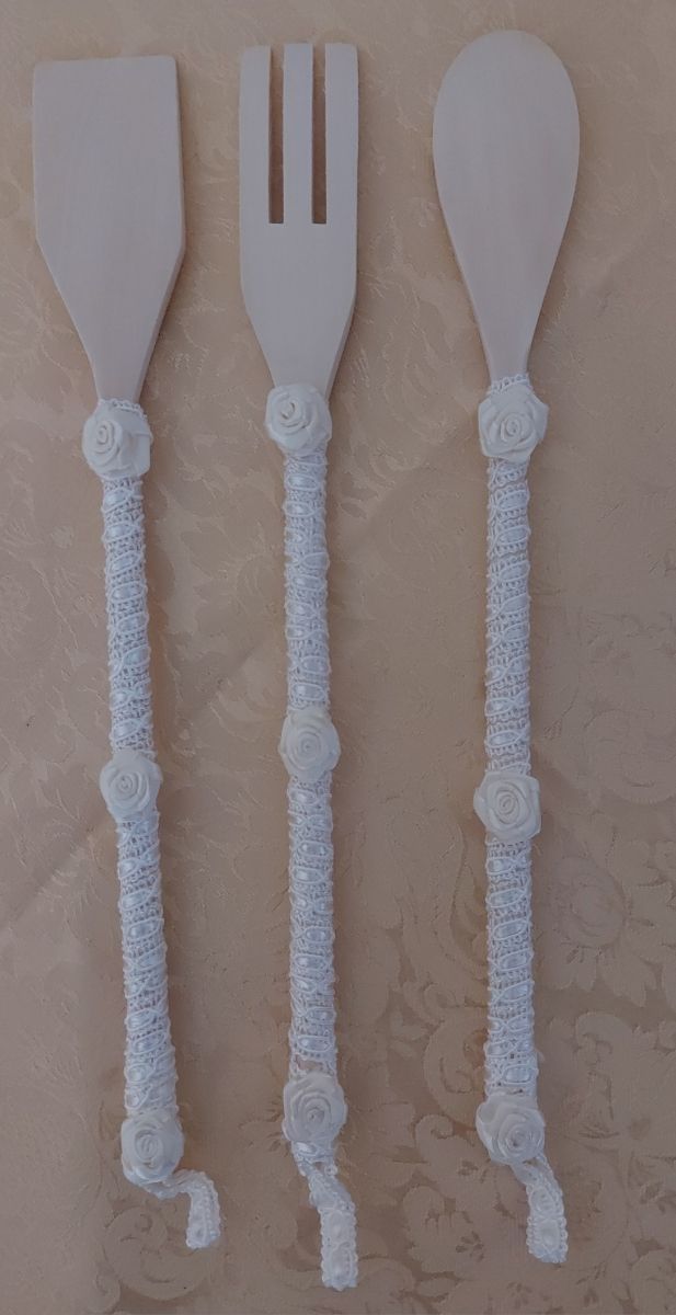 Tris utensili da cucina in legno.