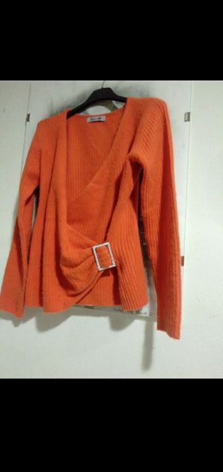 Jersey de lana naranja con frunce hebilla lateral.