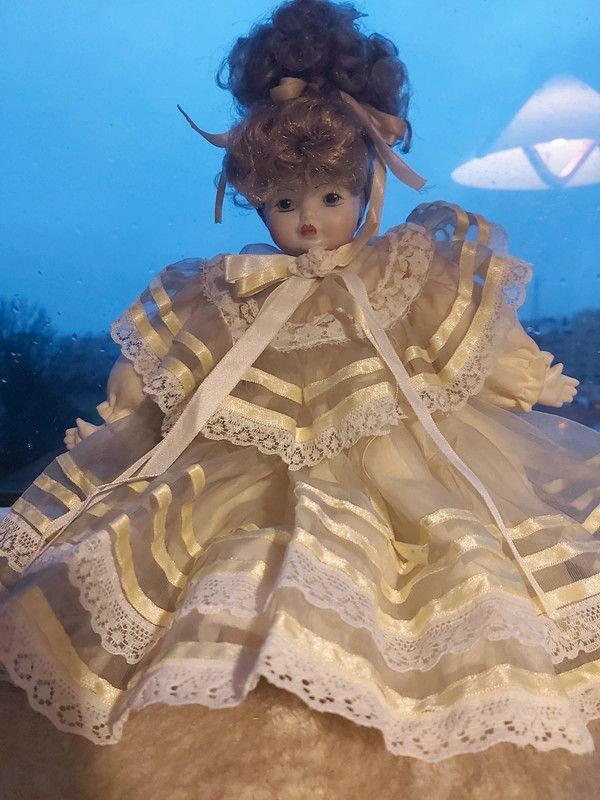 Boneca porcelana antiga com vestido em tom amarelo