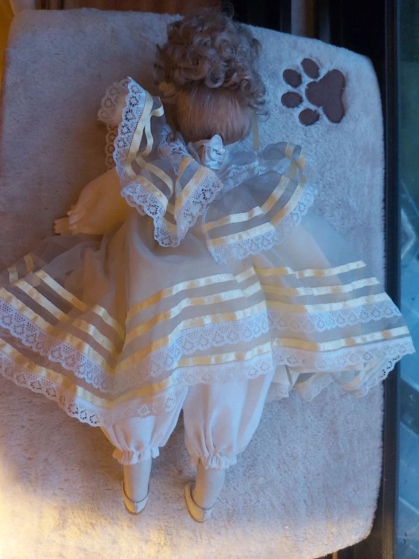 Boneca porcelana antiga com vestido em tom amarelo
