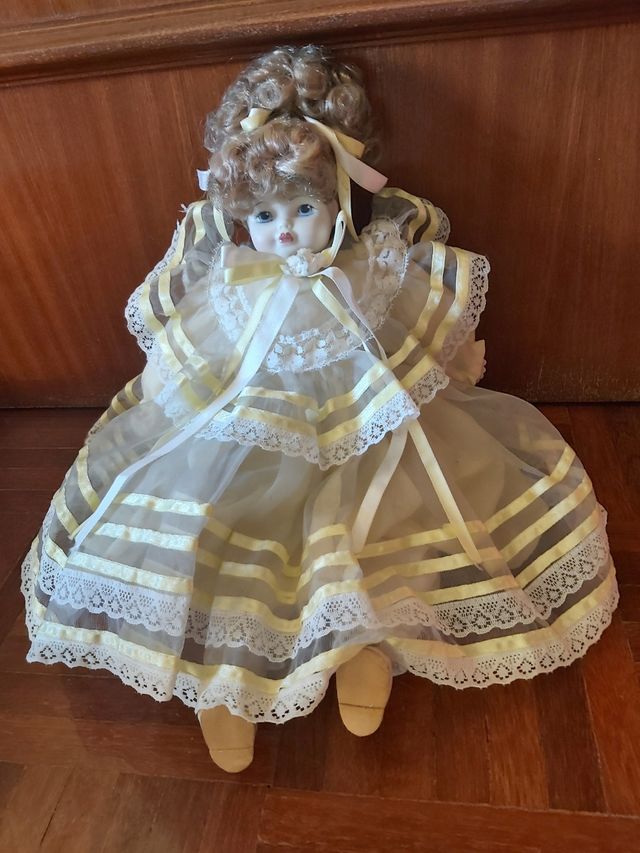 Boneca porcelana antiga com vestido em tom amarelo