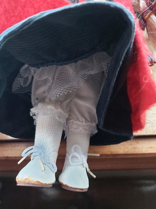 Boneca de porcelana com boina e casaco vermelho