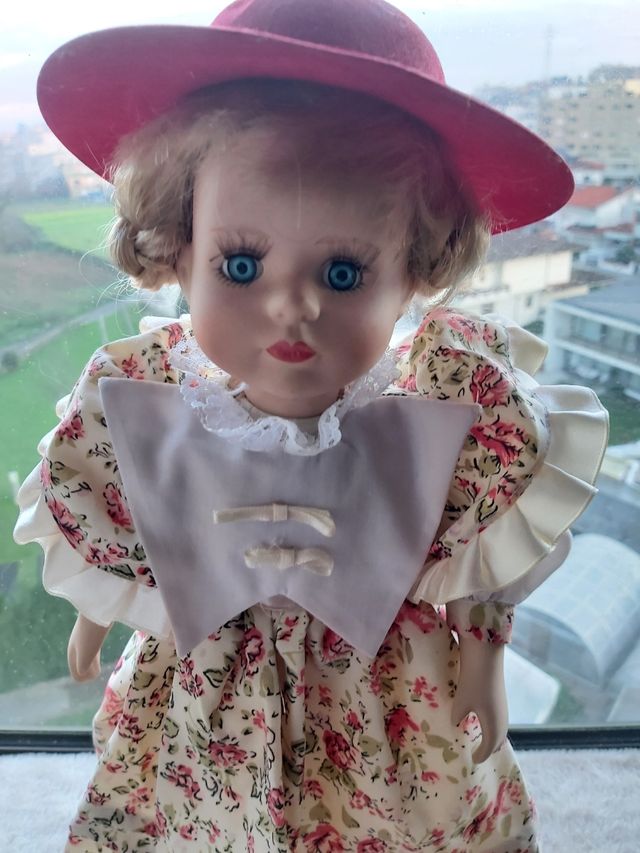 Boneca de porcelana antiga com vestido às flores