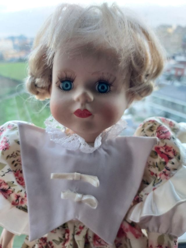 Boneca de porcelana antiga com vestido às flores