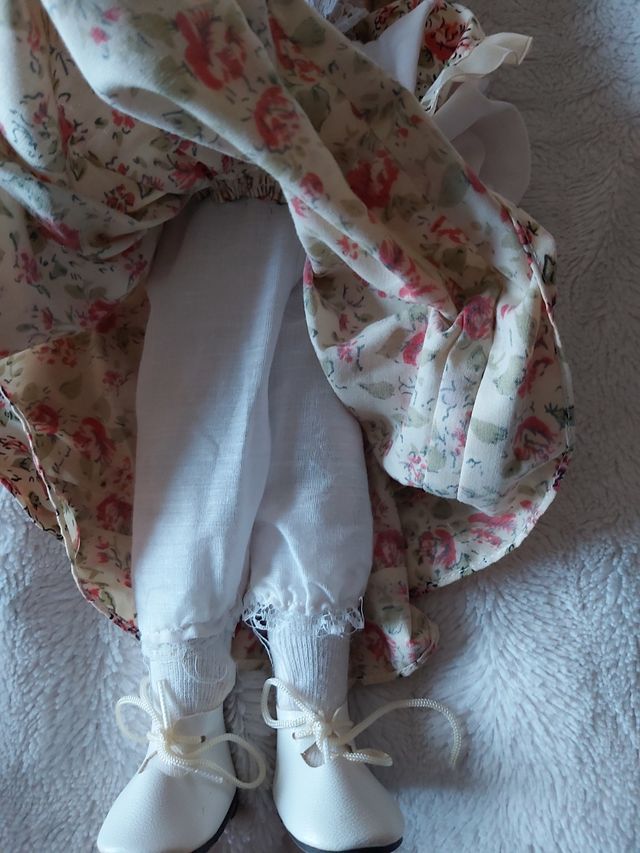 Boneca de porcelana antiga com vestido às flores