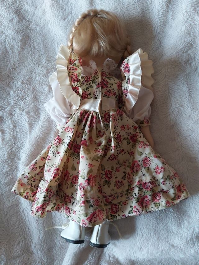 Boneca de porcelana antiga com vestido às flores