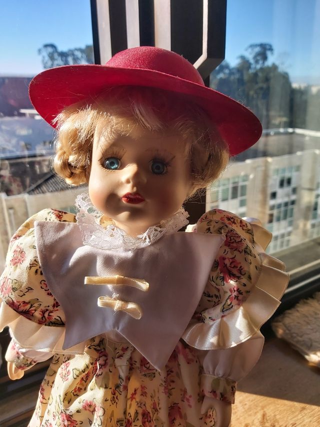 Boneca de porcelana antiga com vestido às flores