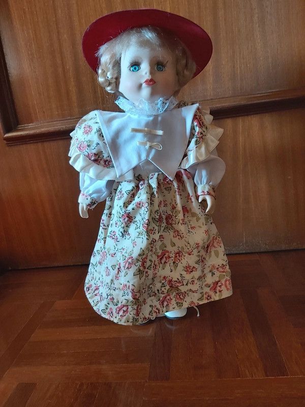 Boneca de porcelana antiga com vestido às flores