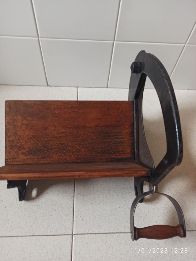 Antiguo cortador de pan manual en hierro y madera