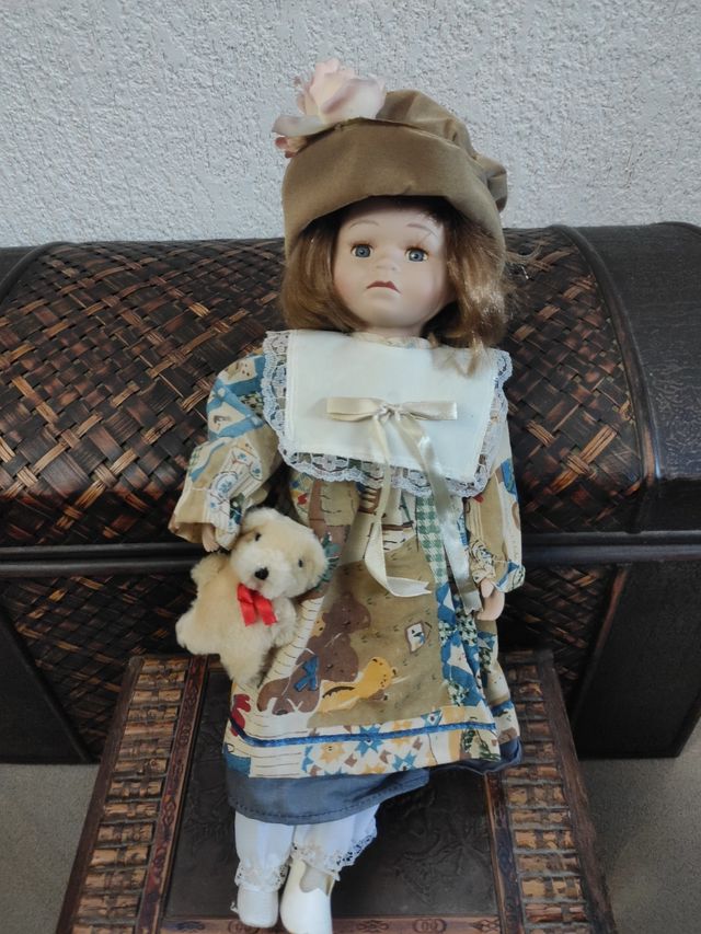 Muñeca de porcelana con peluche
