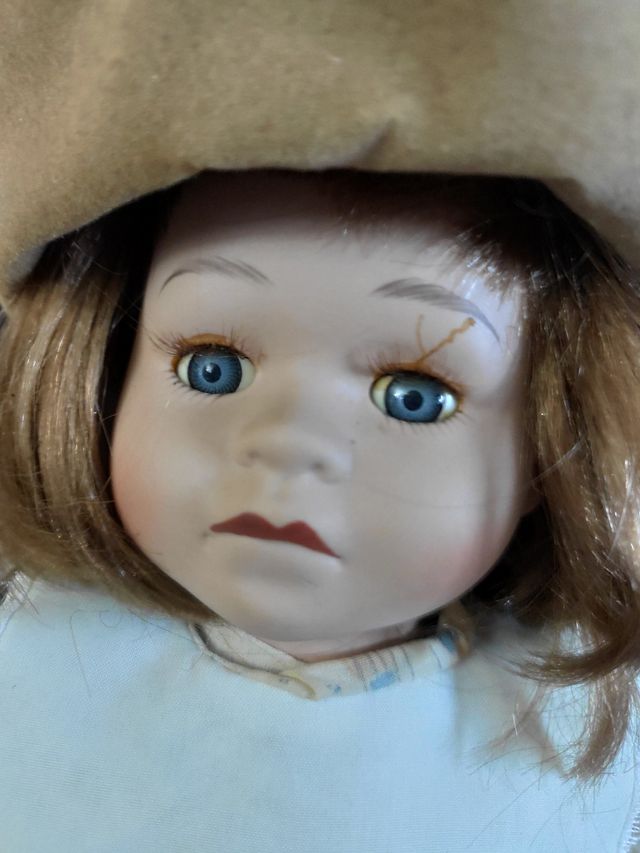 Muñeca de porcelana con peluche