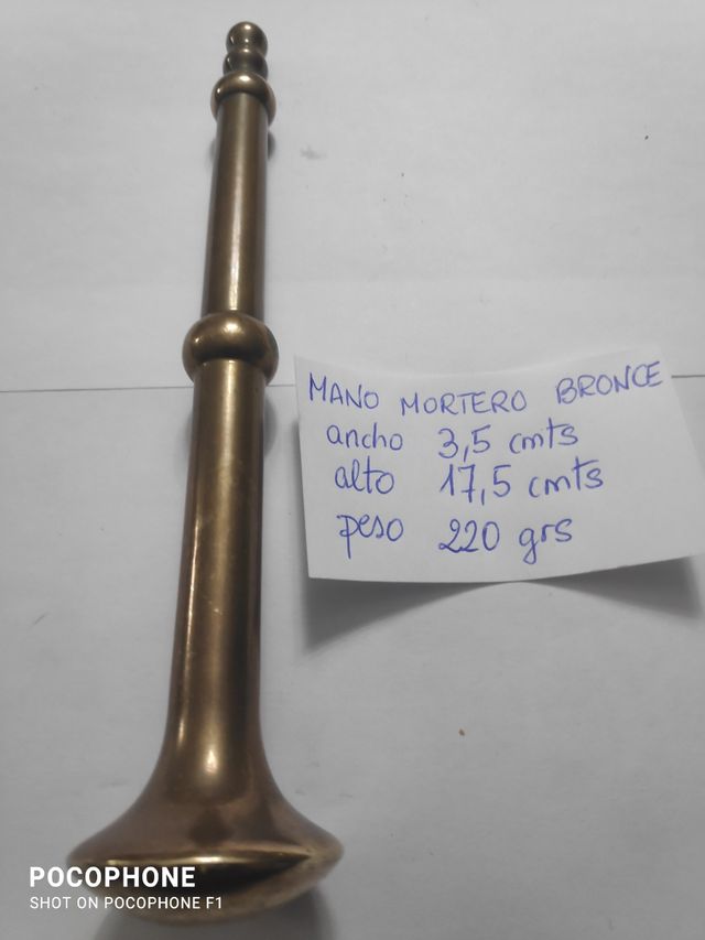 mano de mortero de bronce
