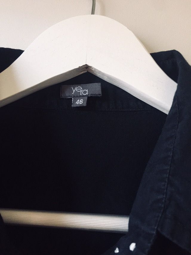 Camisa negra bordada, con botonadura invisible.