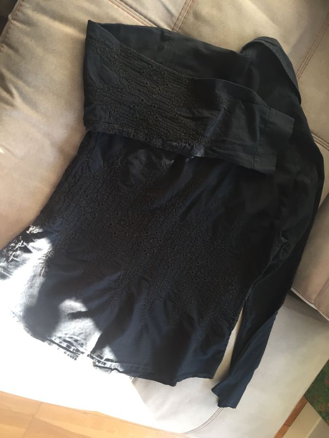 Camisa negra bordada, con botonadura invisible.