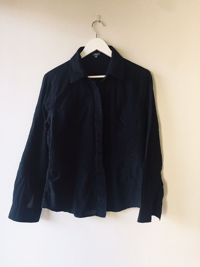 Camisa negra bordada, con botonadura invisible.
