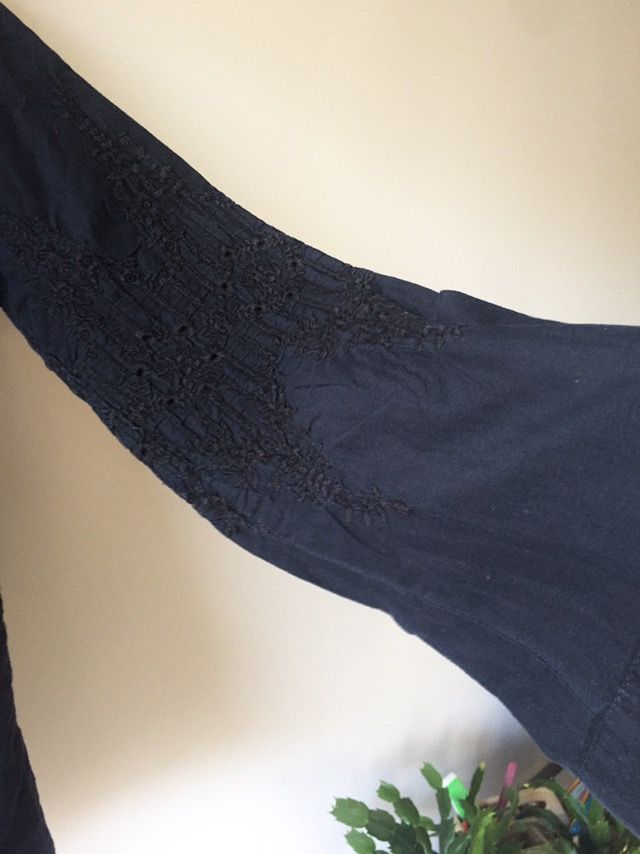 Camisa negra bordada, con botonadura invisible.