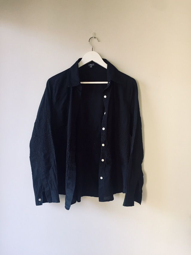 Camisa negra bordada, con botonadura invisible.