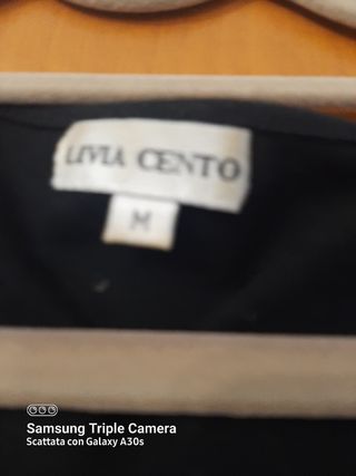 Blusa nera con applicazioni nel collo. 40% lana