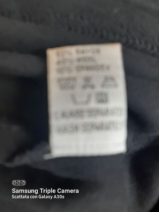 Blusa nera con applicazioni nel collo. 40% lana