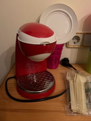 Cafetera de color rojo, y accesorios de juguete.