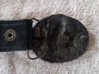 Cinturón de cuero con hebilla de caballos.