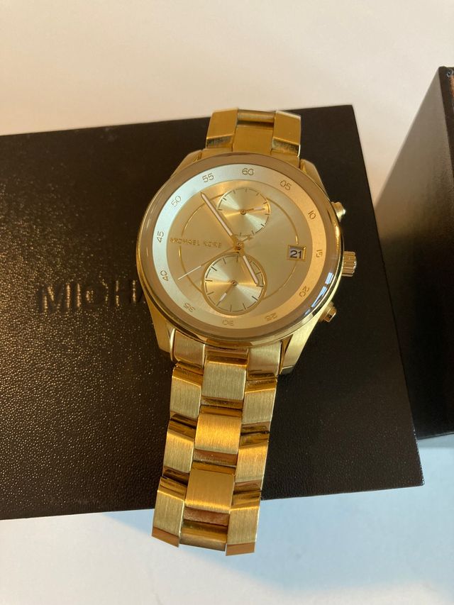 Reloj cronógrafo Michael Kors dorado.